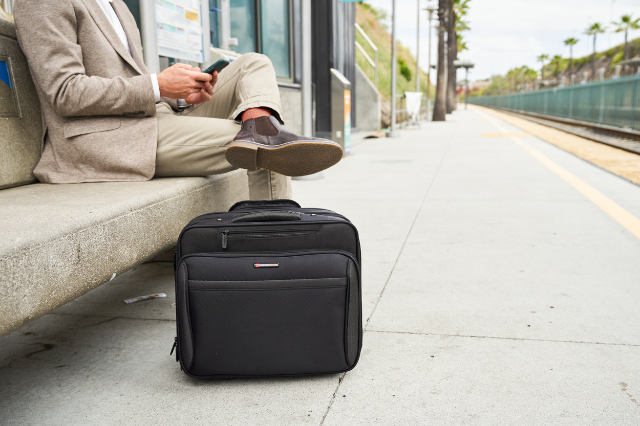 Traveler sitting with suitcase at train station