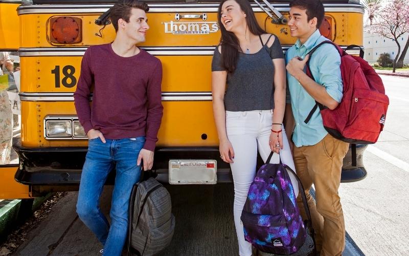 teenagers holding different types of backpacks