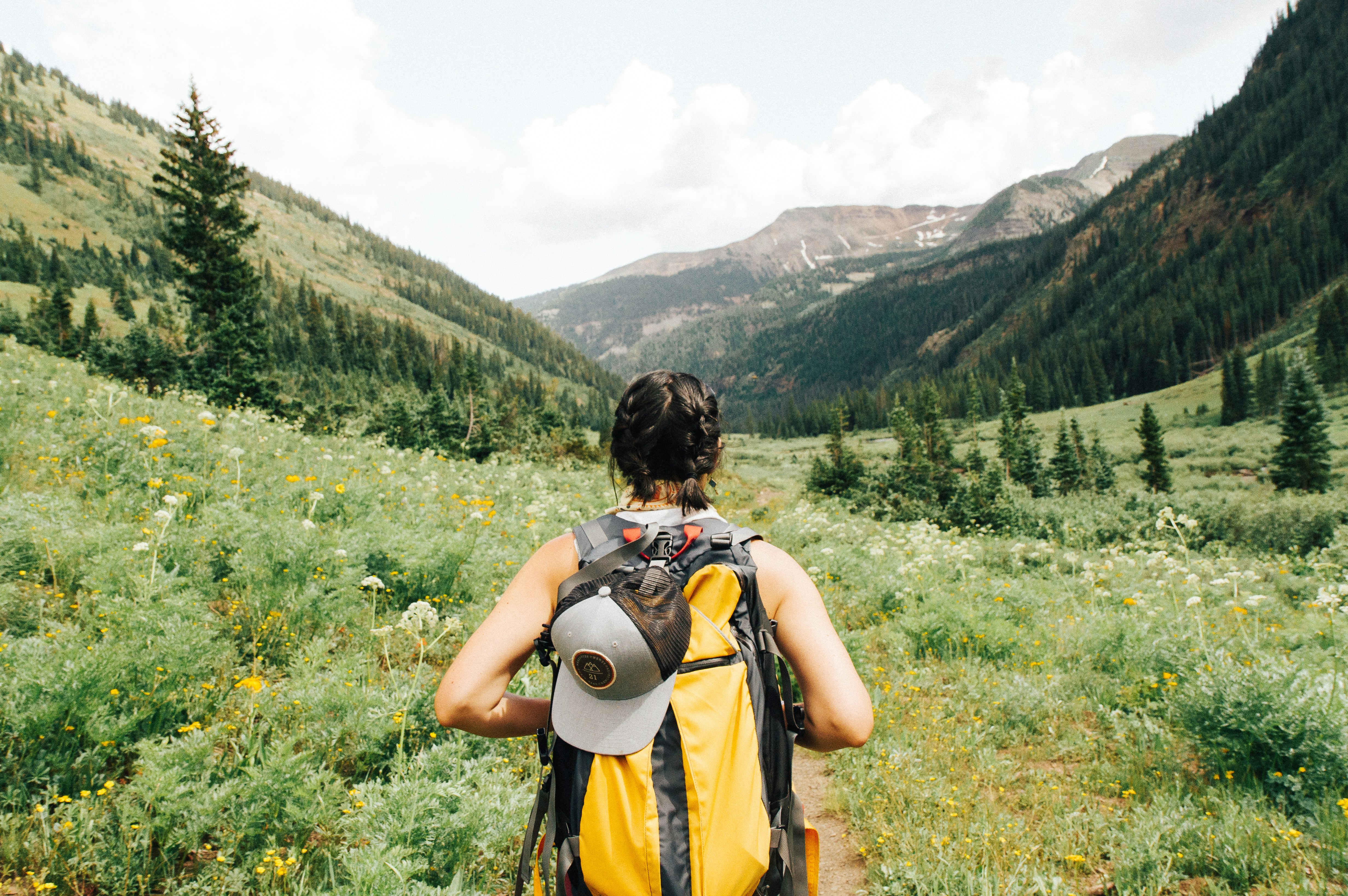 a girl hiking in the mountains wearing a backpack