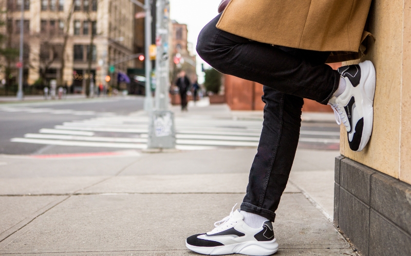 man wearing a long coat and sneakers