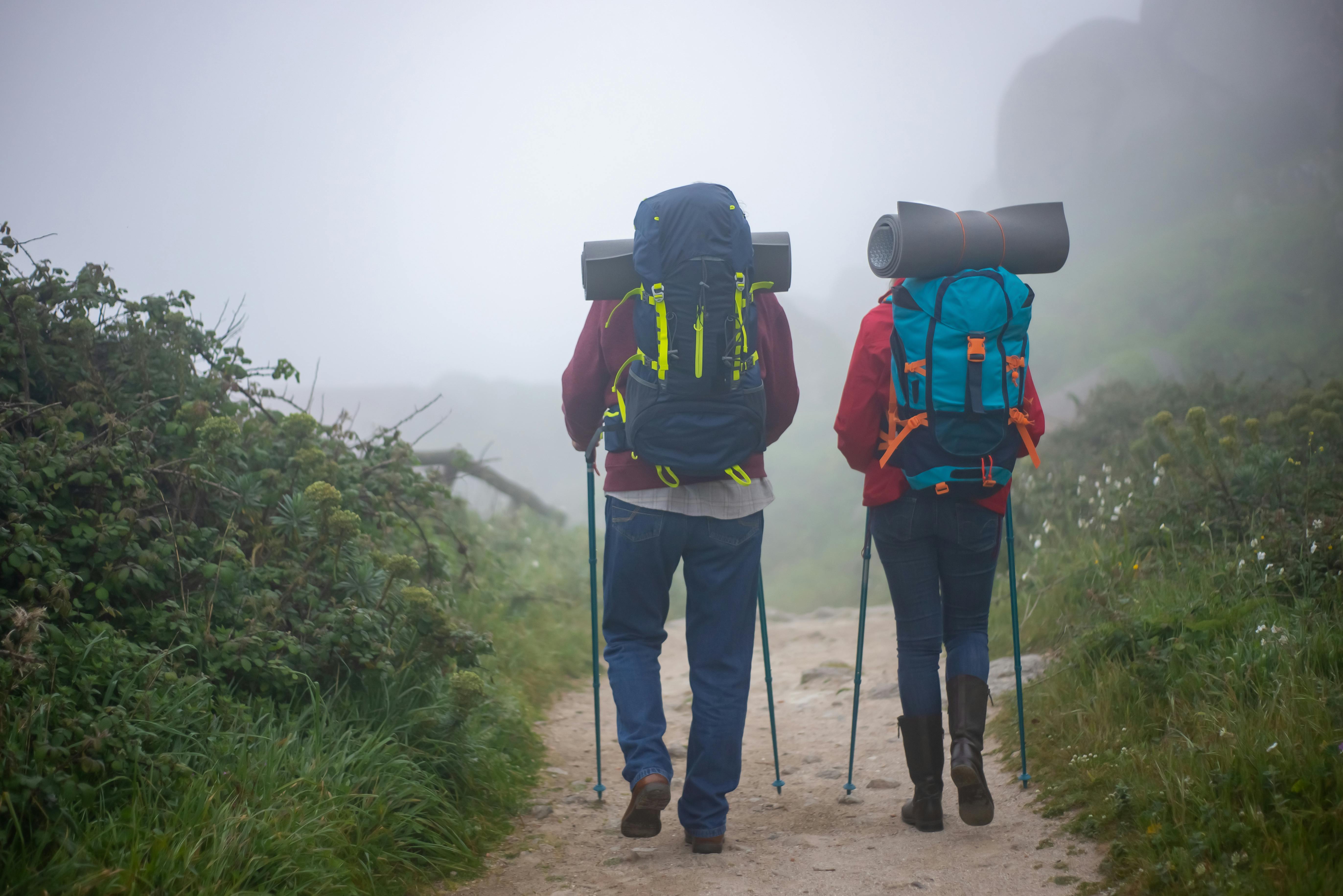 hikers in the mountain walking through fog