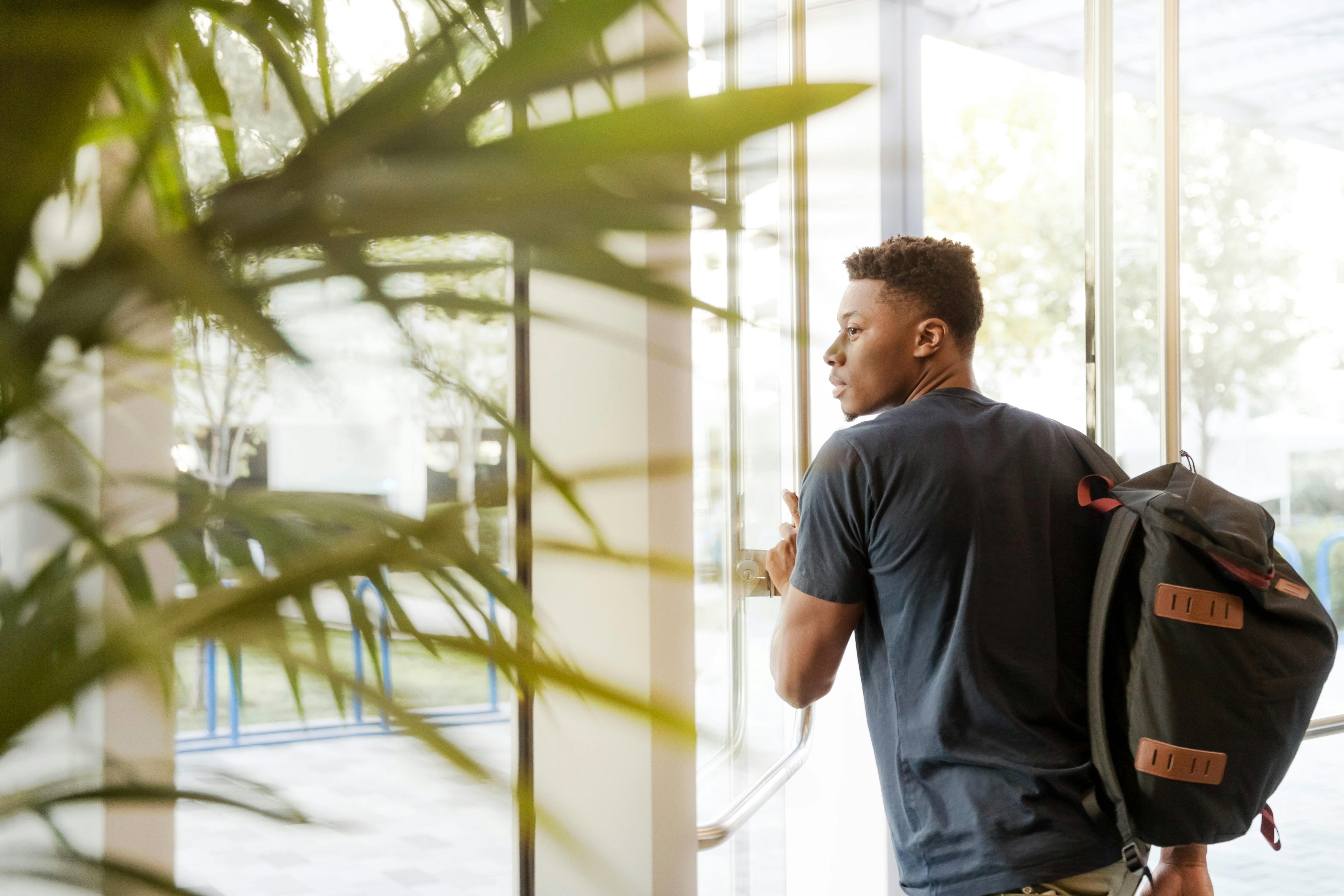 student with his packpack going out of the college