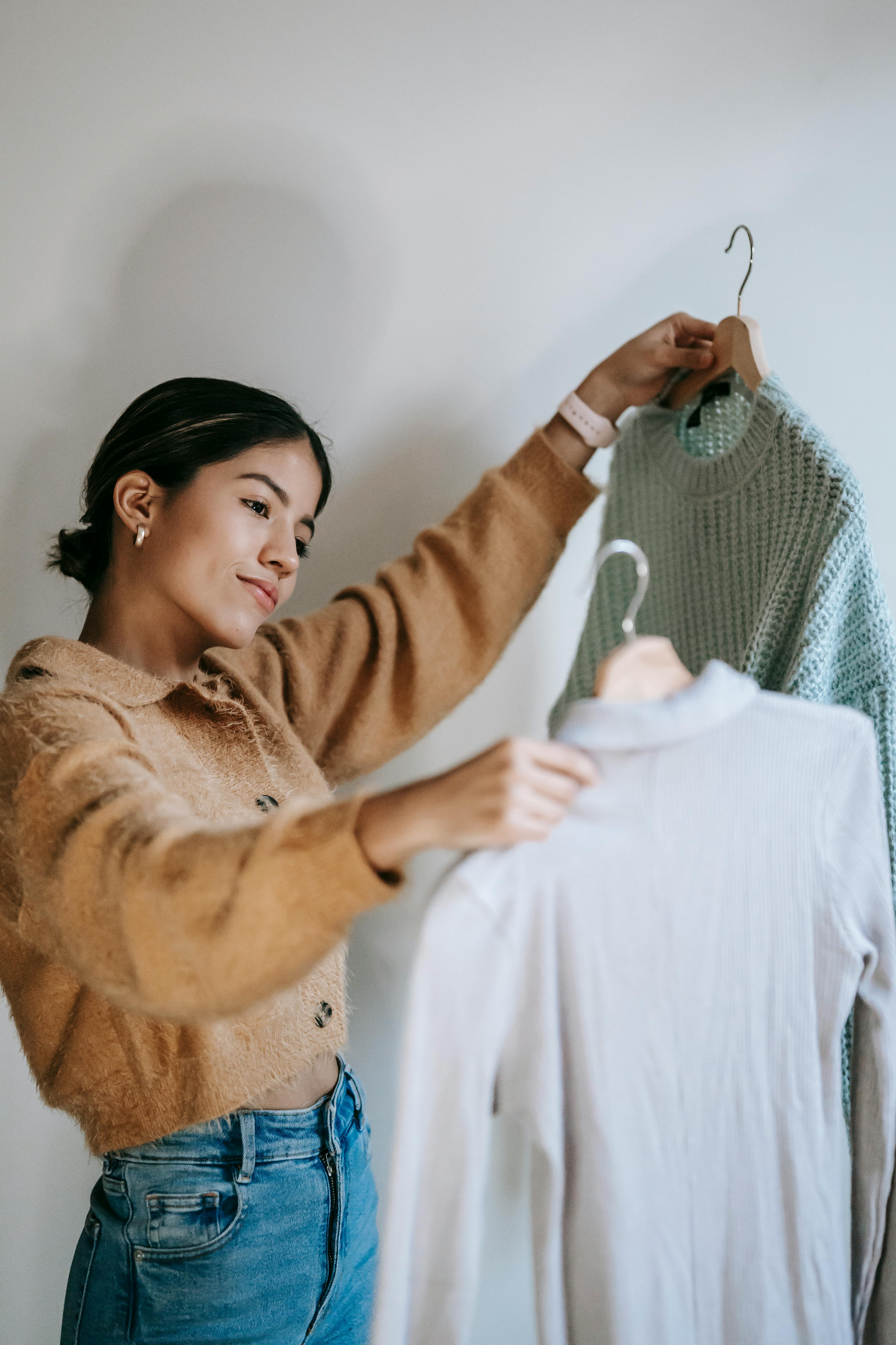 girl choosing between two capsule wardrobe shirts girl choosing between two capsule wardrobe shirts