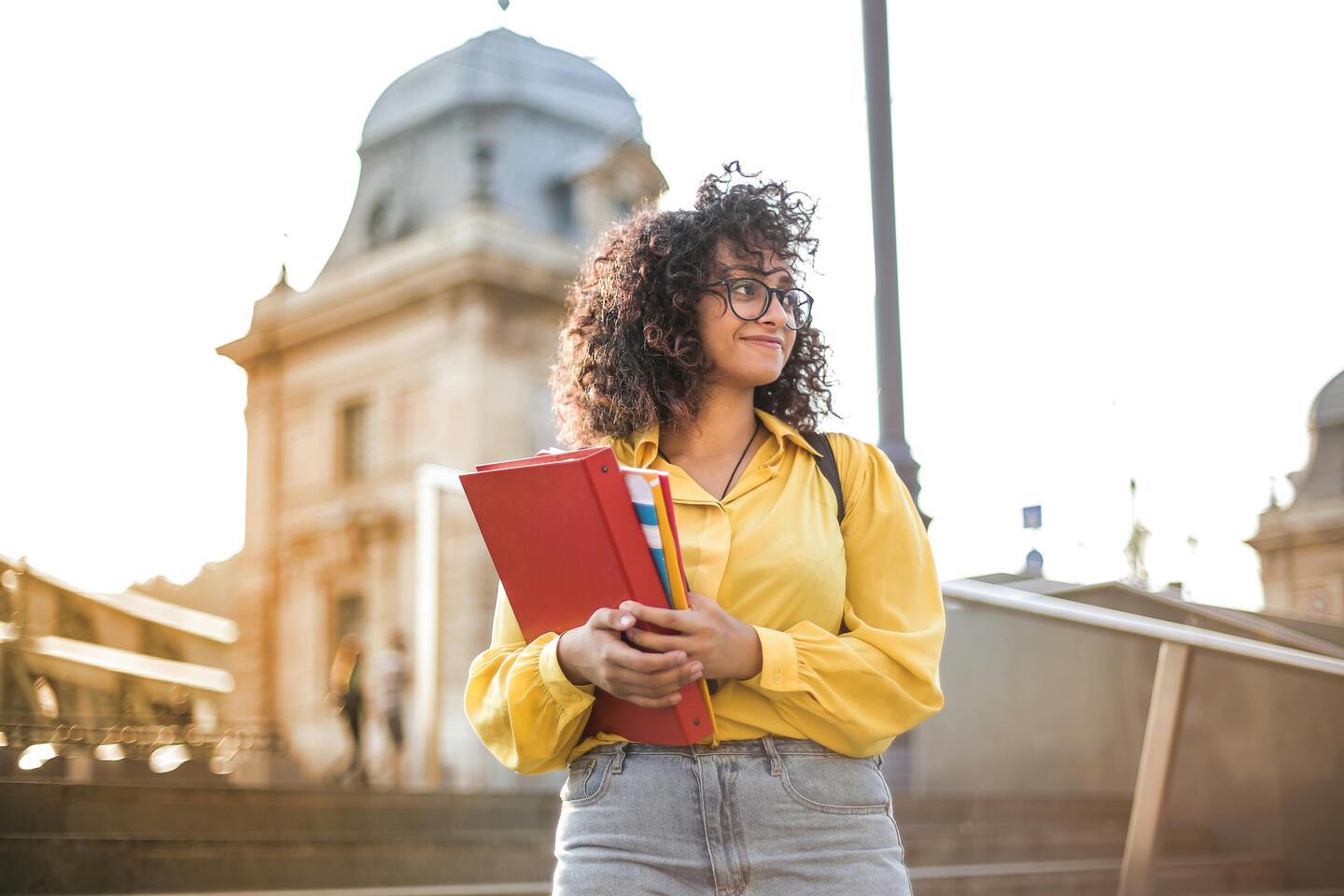 a student standing in front of the college
