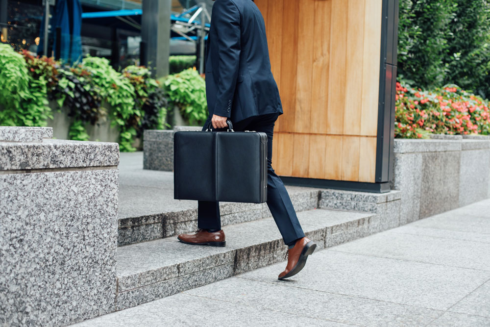 man carrying a leather briefcase